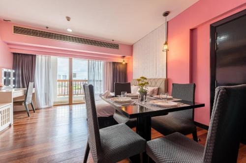 a dining room with pink walls and a table and chairs at Sunway Suite 4pax 1min to Pyramid Mall Sunway Lagoon in Petaling Jaya