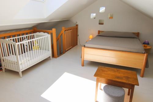 - une chambre avec un lit et un lit bébé dans l'établissement Le Belvosgien, à Gérardmer