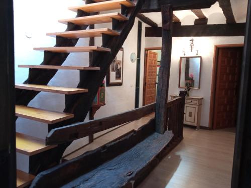 a wooden spiral staircase in a house with a hallway at SOLAR de 1709 in Pradillo