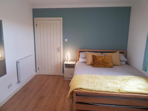 1 dormitorio con 1 cama con pared azul en Skeabostview Brand New Self catering en Skeabost