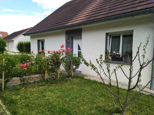 een wit huis met roze bloemen in een raam bij Séjour chaleureux chambre chez l habitant in Torpes