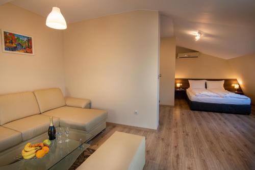 a living room with a couch and a bed at Family Hotel Konstantinovi in Kyustendil