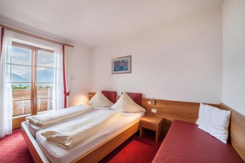een slaapkamer met een groot bed en een raam bij Hahnenkamm Rainegg in Schenna