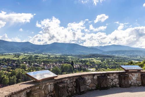 a view of a city from a stone wall with mountains at Hotel La Diligence in Obernai