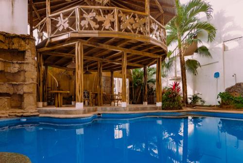 un resort con piscina di fronte a un edificio di Hostal Poseidon a Puerto Cayo