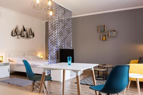 ケストヘイにあるFelhő Vendégházのテーブル、椅子、ベッドが備わる客室です。