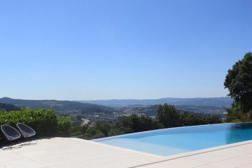a swimming pool with a view of the mountains at Quinta Milhão - Casa do Pomar in Guimarães
