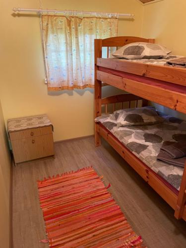 1 Schlafzimmer mit 2 Etagenbetten und einem Teppich in der Unterkunft Metskonna Forest House in Nõva