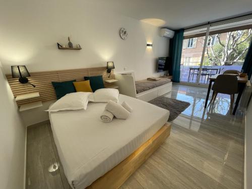 een slaapkamer met een groot bed en een woonkamer bij Chaleureux studio, 200m de la plage, parking, wifi in Roquebrune-Cap-Martin