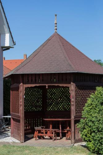 a large wooden pavilion with a picnic table in it at Felhő Vendégház in Keszthely