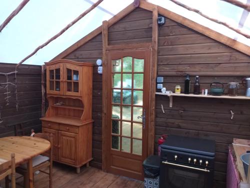 a wooden cabin with a kitchen and a table at Destination Ailleurs in Castellane