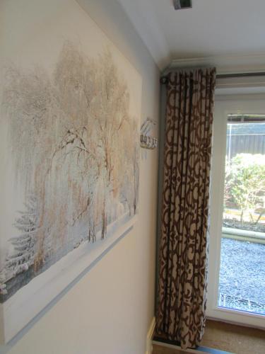 a painting on a wall next to a window at Willow Lodge Hambleton in Poulton le Fylde