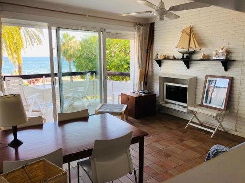 a living room with a dining room table and a view of the ocean at Fragata Beach Seaview in Sitges
