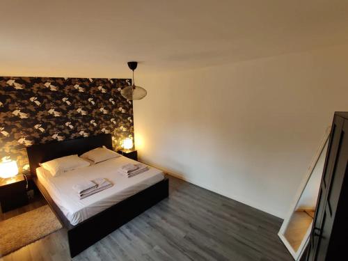 - une chambre avec un lit orné d'un mur fleuri dans l'établissement Homefleur - Grand appartement avec jardin 4-6 personnes, à Honfleur