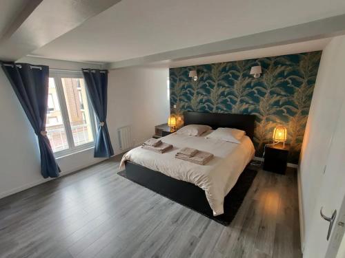 - une chambre avec un grand lit et du papier peint floral dans l'établissement Homefleur - Grand appartement avec jardin 4-6 personnes, à Honfleur