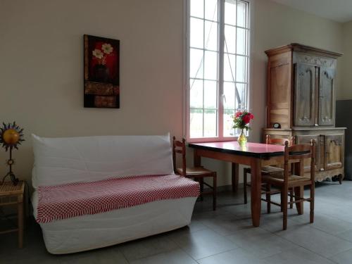 uma sala de estar com uma mesa e uma cadeira em LA MAISON D'ALIDA em Nueil-sous-Faye
