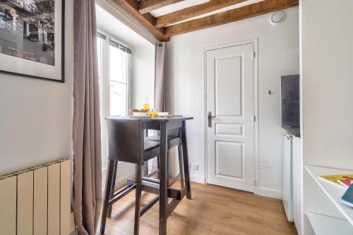 une petite table dans une cuisine avec une fenêtre dans l'établissement The Perfect Studio in the Heart of Paris (5M), à Paris