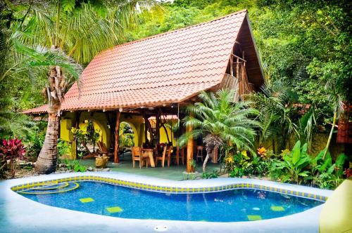 un resort con piscina di fronte a una casa di Nosara Sunrise Bed and Breakfast a Nosara