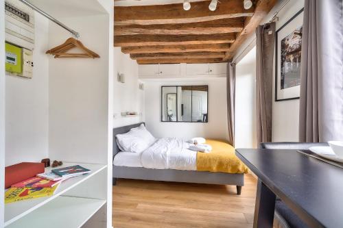 une petite chambre avec un lit et un bureau dans l'établissement The Perfect Studio in the Heart of Paris (5M), à Paris