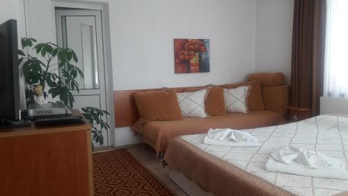a living room with a couch and a bed at Guest House Stoletnika in Yagodina