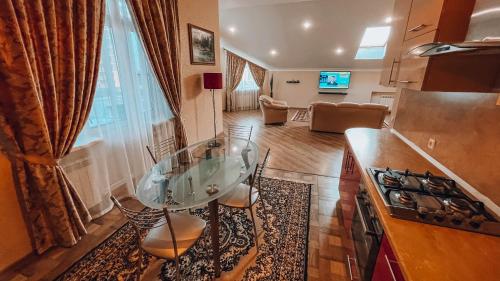 una cocina con una mesa de cristal en el medio de una habitación en Villa Valmont, en Krasnodar