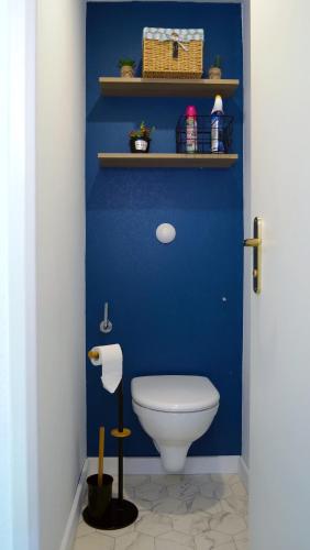 La salle de bains bleue est pourvue de toilettes et d'un mur bleu. dans l'établissement Studio à 8 min à pied du Futuroscope – 1/4 pers, à Chasseneuil-du-Poitou