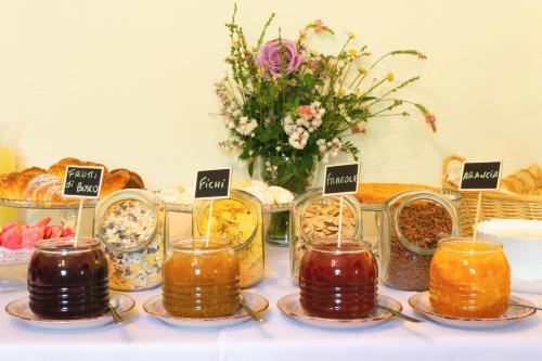 a table with jars of food and a vase of flowers at Podere Belvedere in Barberino di Mugello