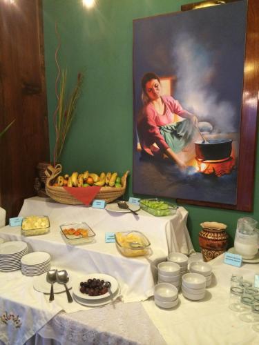 a table with white dishes and a painting of a woman at Royal Inn Hotel Puno in Puno