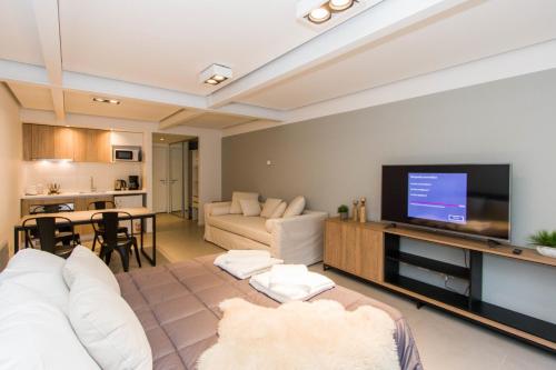 a living room with a couch and a flat screen tv at Austral Departamentos in Ushuaia