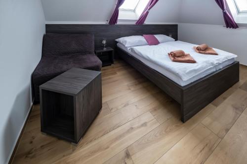 a bedroom with a bed and a chair at Vinařství Herůfek in Zaječí