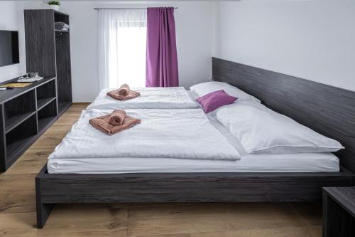 a bedroom with a large bed with towels on it at Vinařství Herůfek in Zaječí