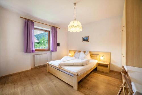 um quarto com uma cama e uma janela com cortinas roxas em Sonnenparadies Apartement 1 em Saltusio