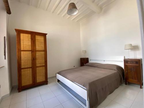 a bedroom with a bed and a dresser in it at Porticciolo in Marina di Campo