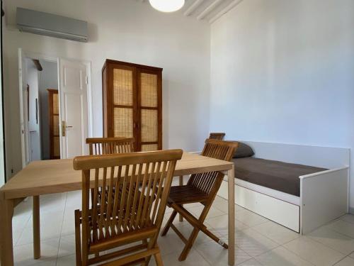 a dining room with a table and chairs and a bed at Porticciolo in Marina di Campo