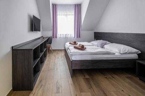 a bedroom with a bed and a dresser with shoes on it at Vinařství Herůfek in Zaječí