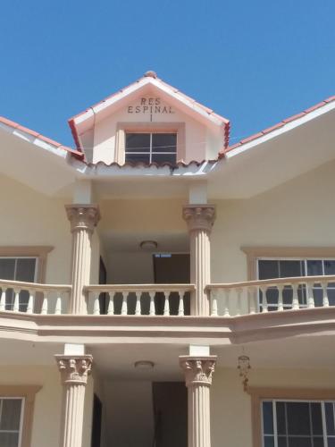 a white house with a balcony on top of it at Rolando share apart in Punta Cana