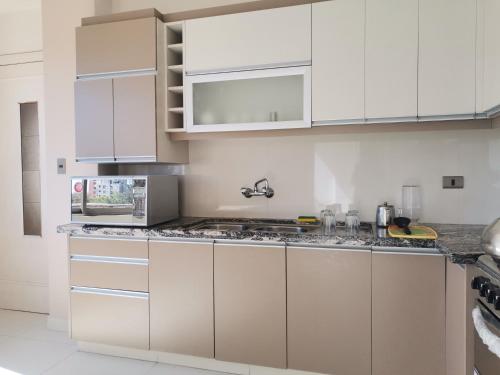 a kitchen with white cabinets and granite counter tops at Hostal Costa De Marfil Suites & Apartamentos in Cochabamba