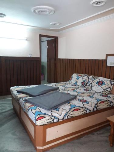 ein Schlafzimmer mit einem Bett mit einer Steppdecke darauf in der Unterkunft Hotel Rajpal Guest House in Dehradun