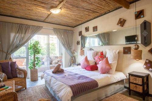 a bedroom with a large bed with pink pillows at Bedrock Guest Studios in Strand