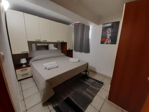 ein kleines Schlafzimmer mit einem Bett und weißen Schränken in der Unterkunft CASE VACANZE FLAMINGO in Policoro
