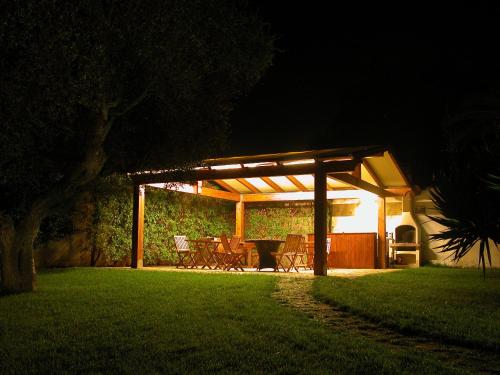 a pavilion with a table and chairs under it at night at B&B QuattroStelle in Cavallino di Lecce