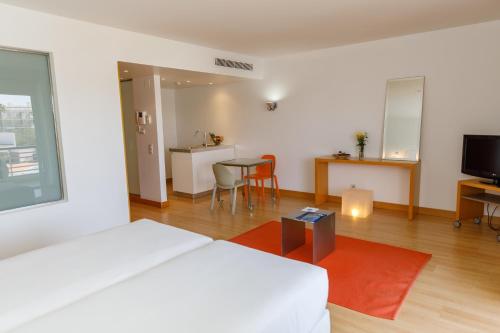 a bedroom with a bed and a table and a kitchen at Marina Club Lagos Resort in Lagos