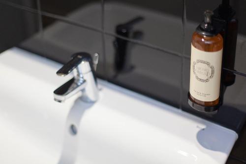 a bathroom sink with a bottle of soap next to it at Emporium Lisbon Suites in Lisbon