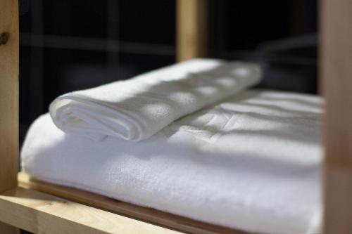 a stack of white towels sitting on a shelf at Emporium Lisbon Suites in Lisbon