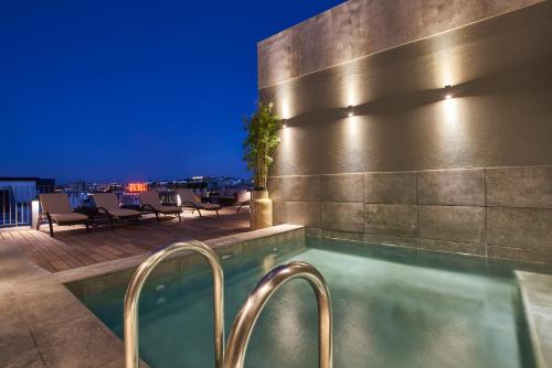 a swimming pool on the rooftop of a hotel at night at PortoBay Marquês in Lisbon