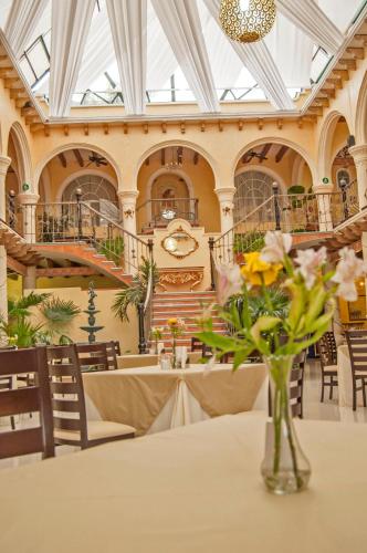 a vase of flowers on a table in a building at Centro Hotel Villa las Margaritas in Xalapa
