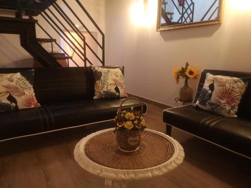 a living room with a couch and a table with a basket of flowers at Casa D'Aldeia in Aldeia da Mata