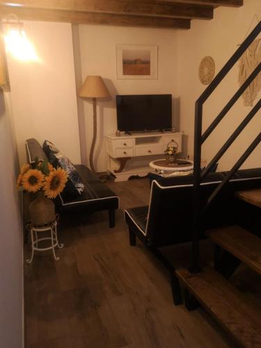 a living room with a couch and a television at Casa D'Aldeia in Aldeia da Mata