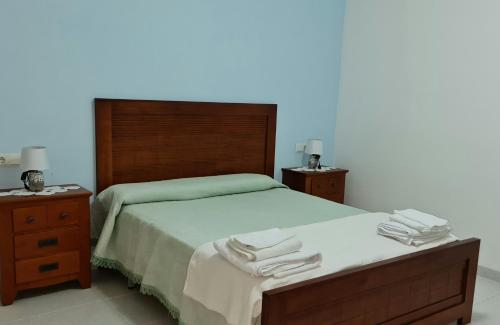 1 dormitorio con 1 cama con 2 mesitas de noche y toallas en Casa Mirador, en Alcanar