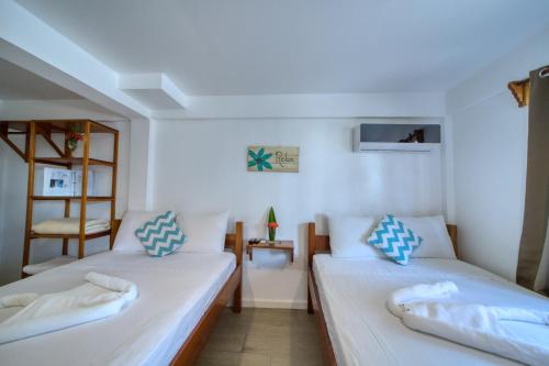 a room with two beds and a chair in it at Placencia Villas in Placencia Village